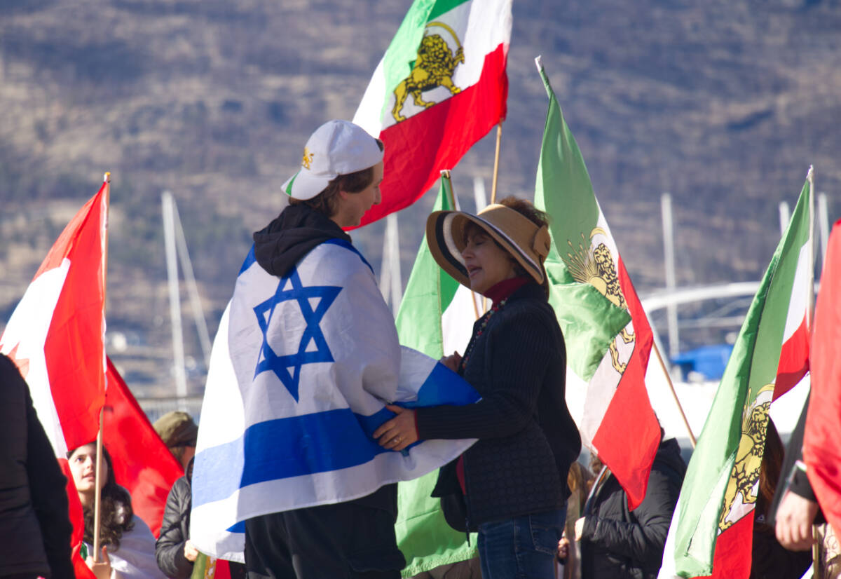 Liam Hrncirik, a Jewish Canadian, speaking to a woman during a gathering at downtown Kelowna&rsquo;s Kerry Park on Sunday, March 1. (Ty Lim/Kelowna Capital News)