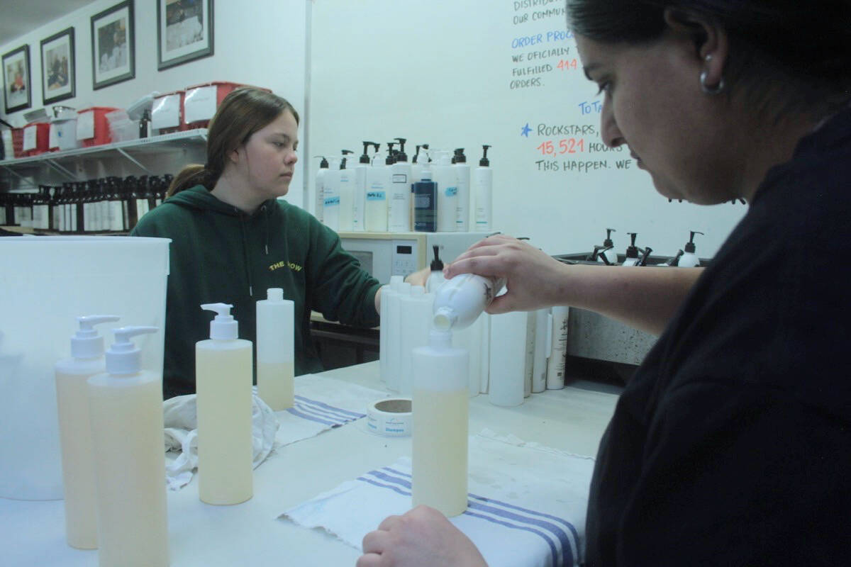 Selena and Carly sort shampoos in the Soap for Hope Vic West warehouse. (Christine van Reeuwyk/Victoria News)