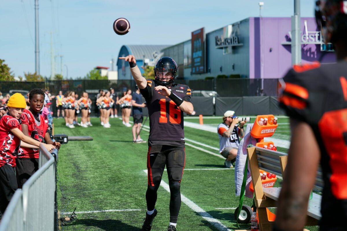 Jarret Doege, quarterback for the B.C. Lions, warms up his arm on the sidelines. (Tony Trozzo/Goldstream Gazette)
